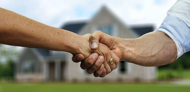 A Real Estate Agent and Homebuyer Shake Hands in Front of a Newly Purchased House in Shreveport Bossier, LA